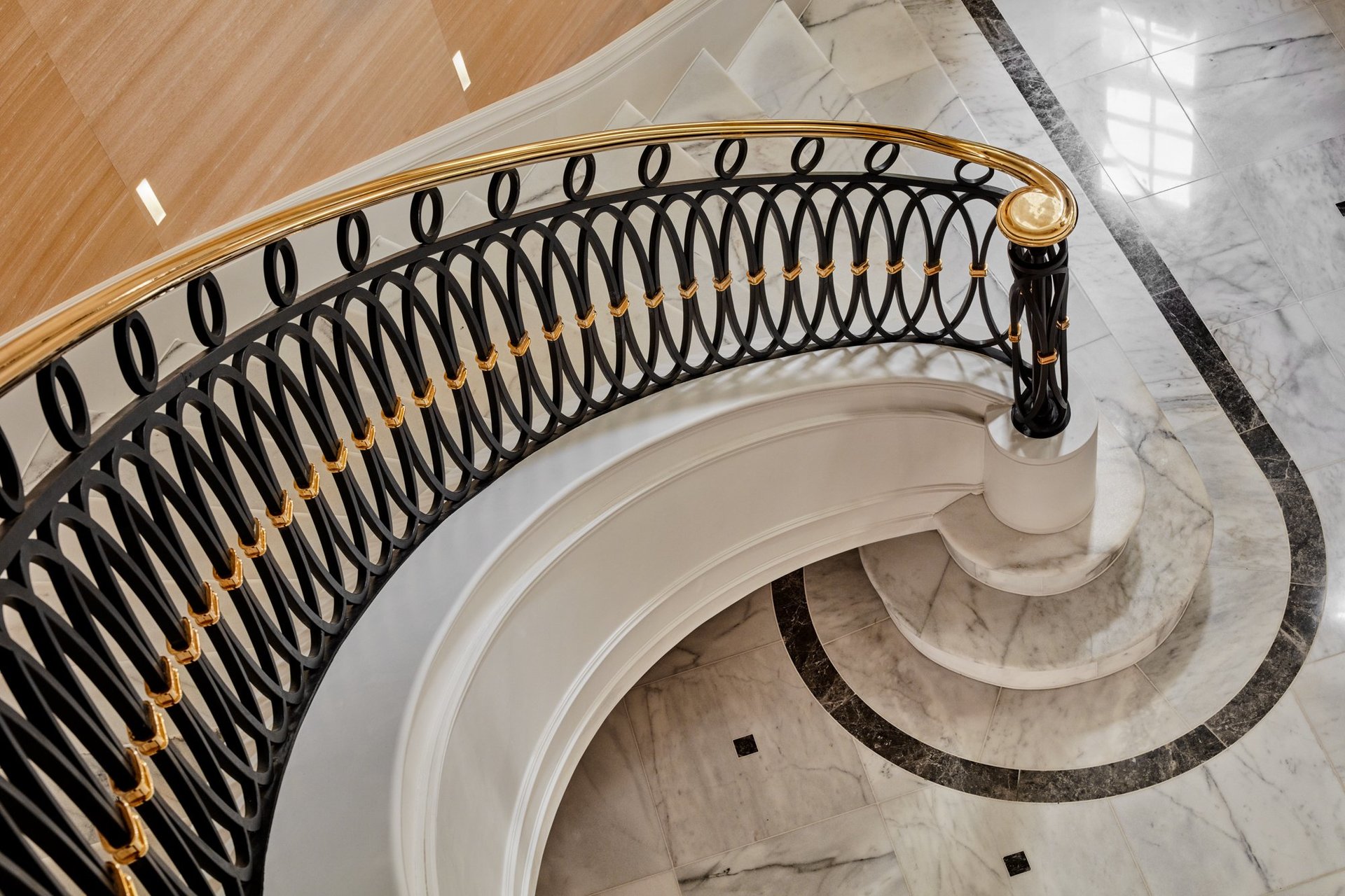 Aerial view of curved staircase with marble floor in luxury home