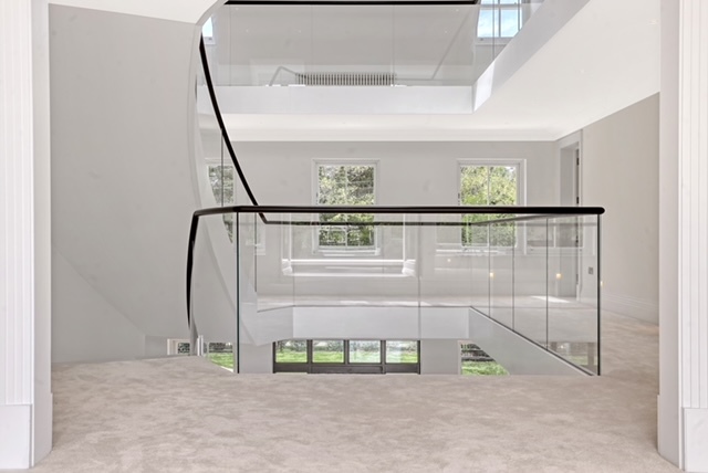 Rear view of luxurious curved stair with glass balustrades
